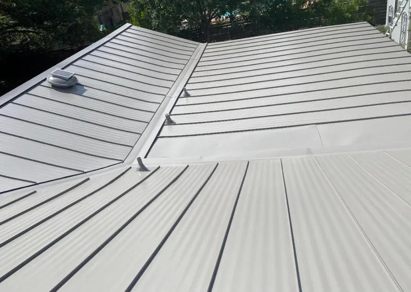 Solar attic fan installed on a metal roof for Roof Ventilation in Muskegon Heights